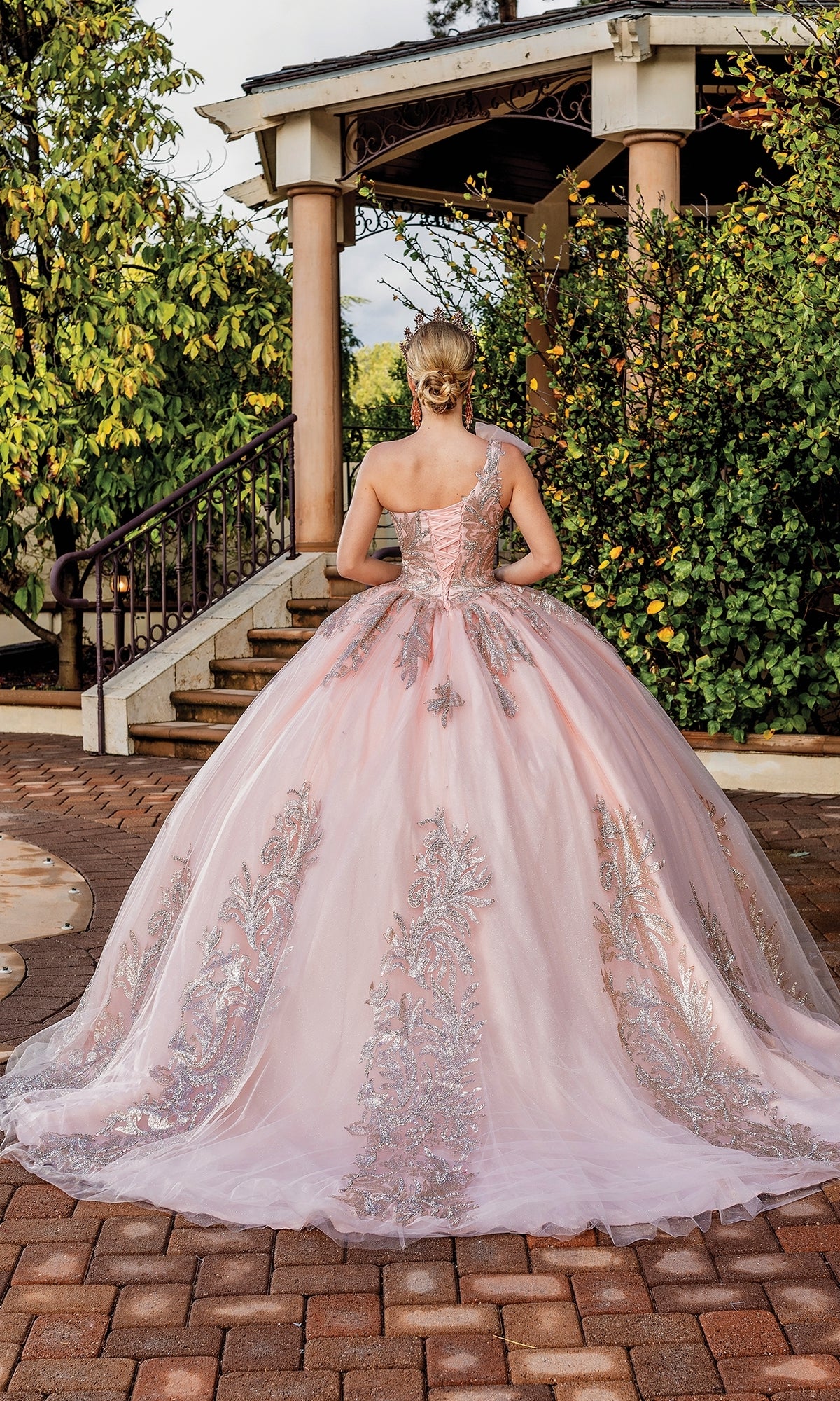 A woman wearing the One-Shoulder Long Quince Dress: Dancing Queen 1733 stands with her back to the camera in front of a gazebo.